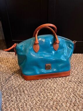 This is a Dooney & Bourke Darcy Teal Patent Leather Satchel handbag.